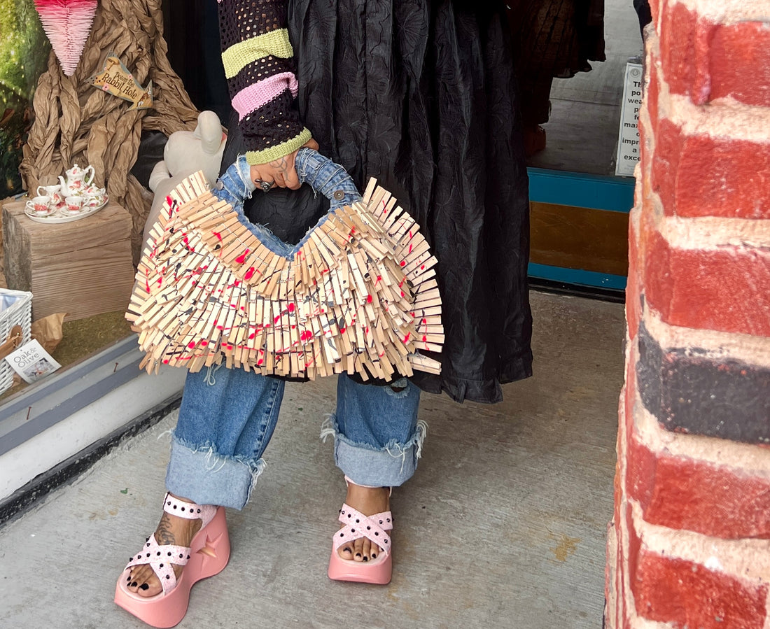 Woman holding and posing with clothespin denim bag wearing pink shoes