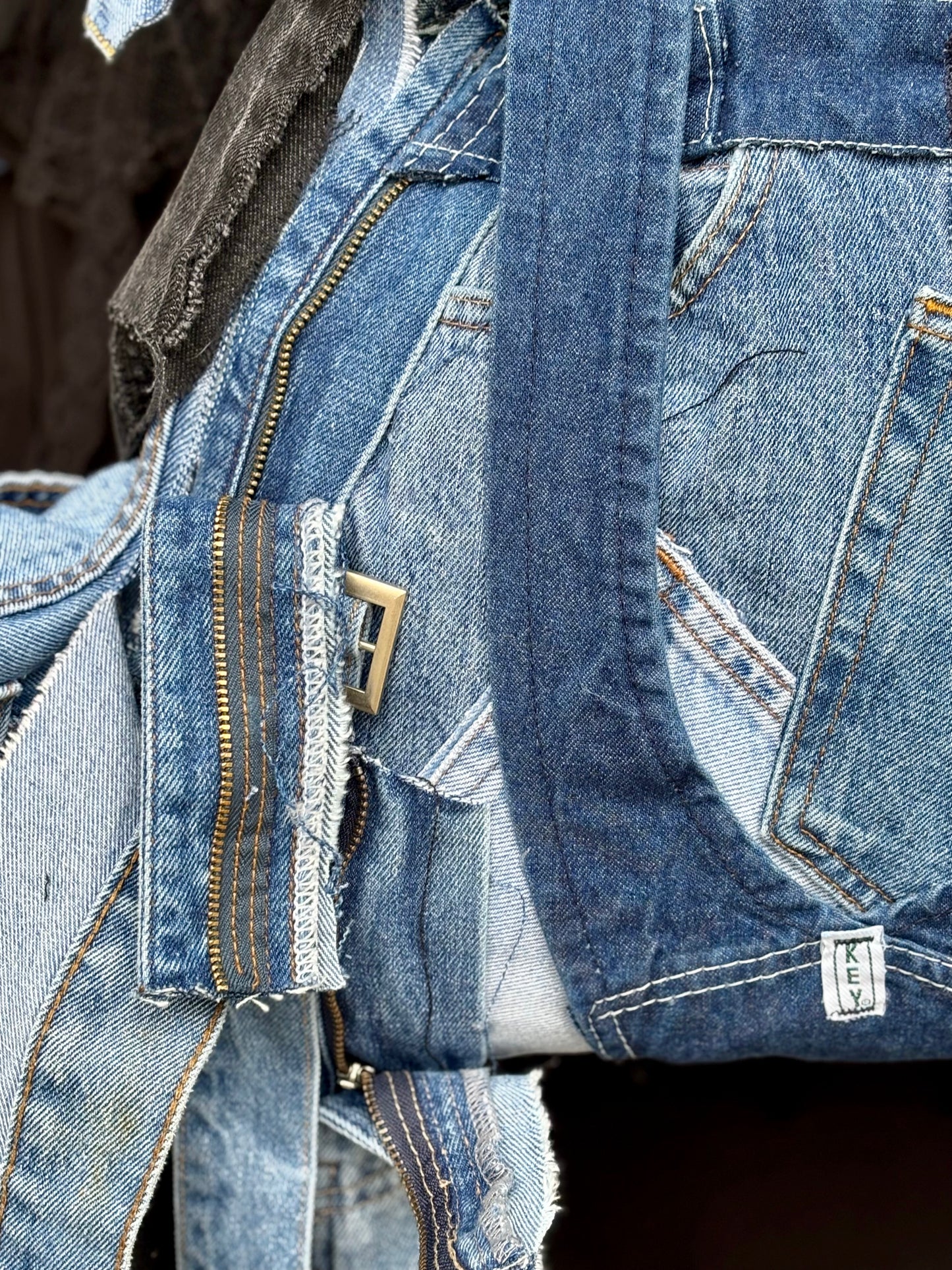 Close-up of blue denim jeans with stitching details on a dark background