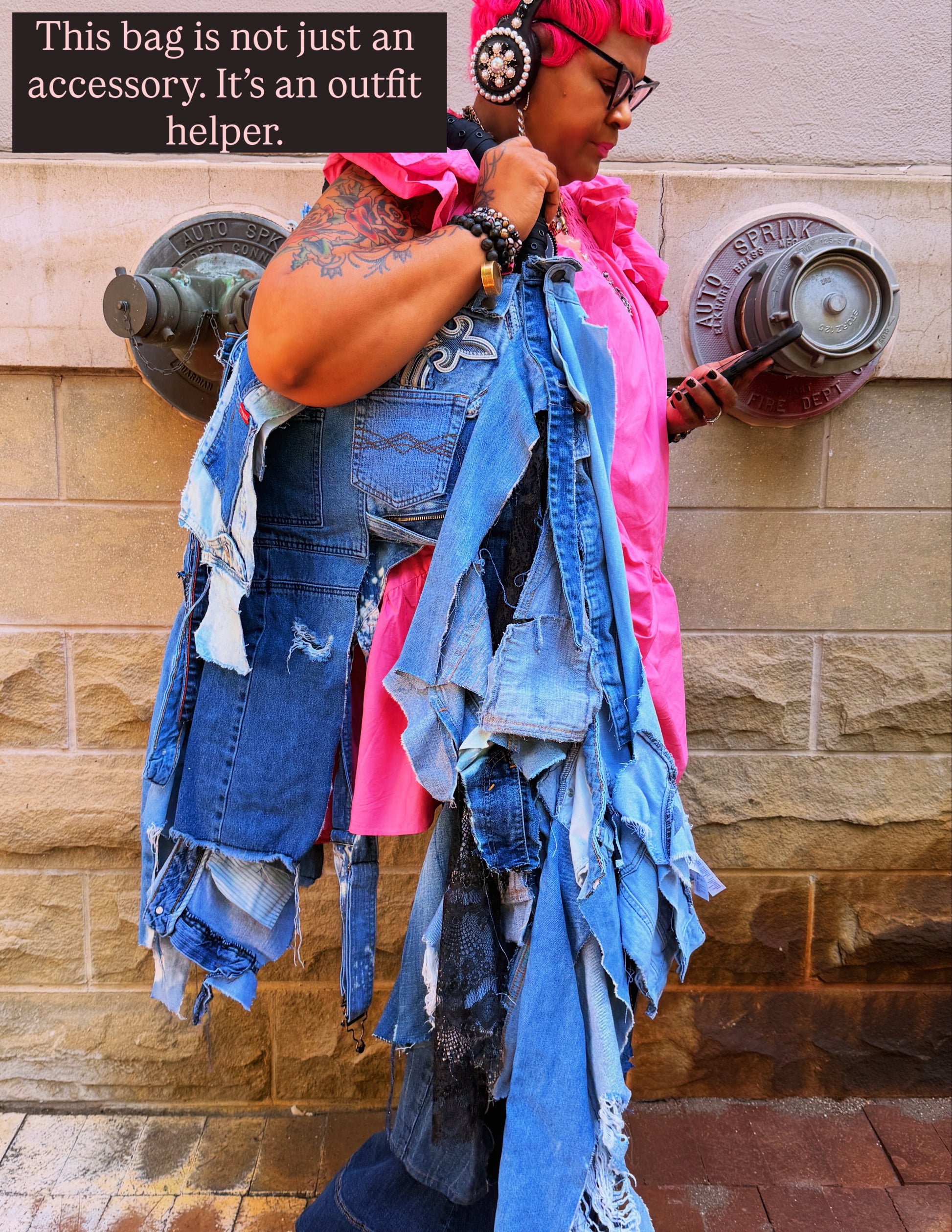 woman leaning on wall showing off ugly denim bag with text: this bag is not just an accessory. It's an outfit helper.