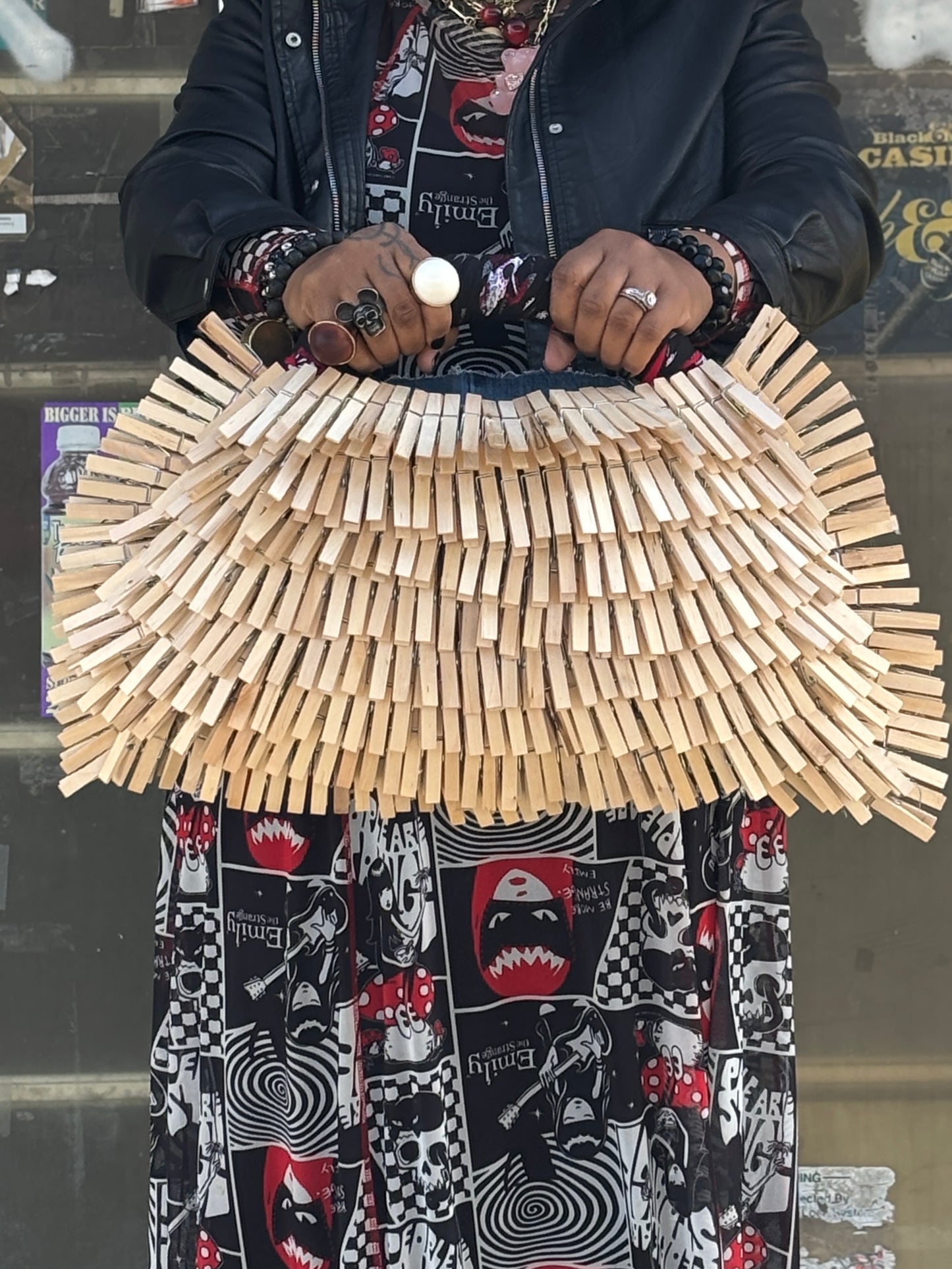 Person holding a bag made of wooden clothespins against a blurred background