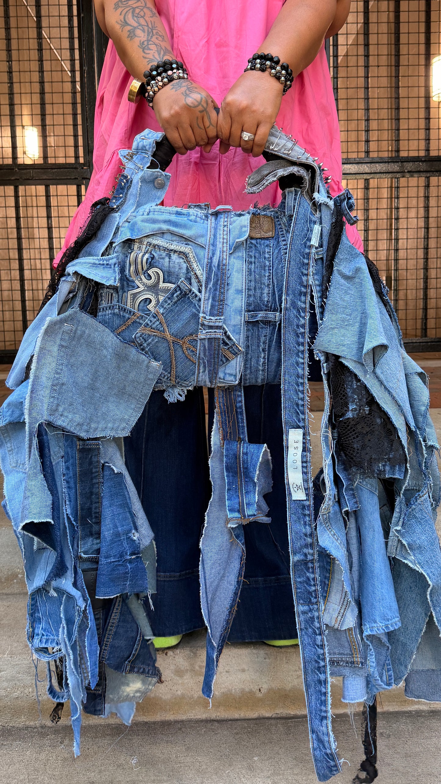 Two-sided handmade ugly denim bag showing mixed blue denim patches, jean pockets, frayed edges, and long shaggy denim pieces.