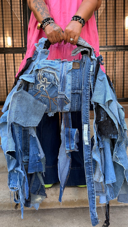 Two-sided handmade ugly denim bag showing mixed blue denim patches, jean pockets, frayed edges, and long shaggy denim pieces.