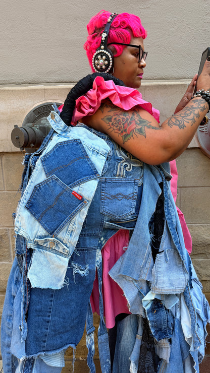 Person wearing an oversized ugly denim janky bag with patchwork pockets, shredded denim strips, black handle, and funky statement styling.