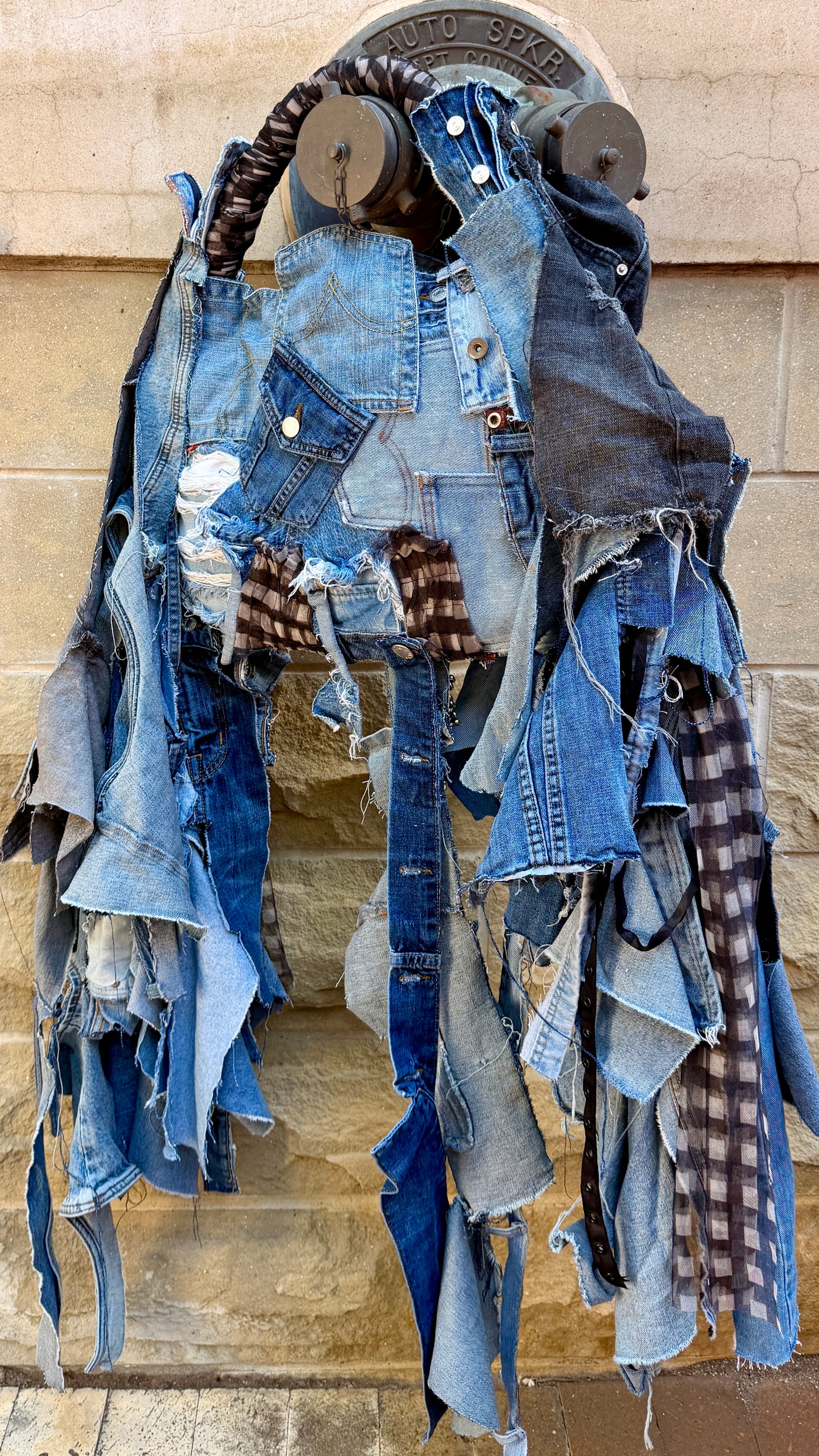 Handmade upcycled ugly denim patchwork bag with hanging denim strips, plaid accents, layered pockets, and safety pin details.