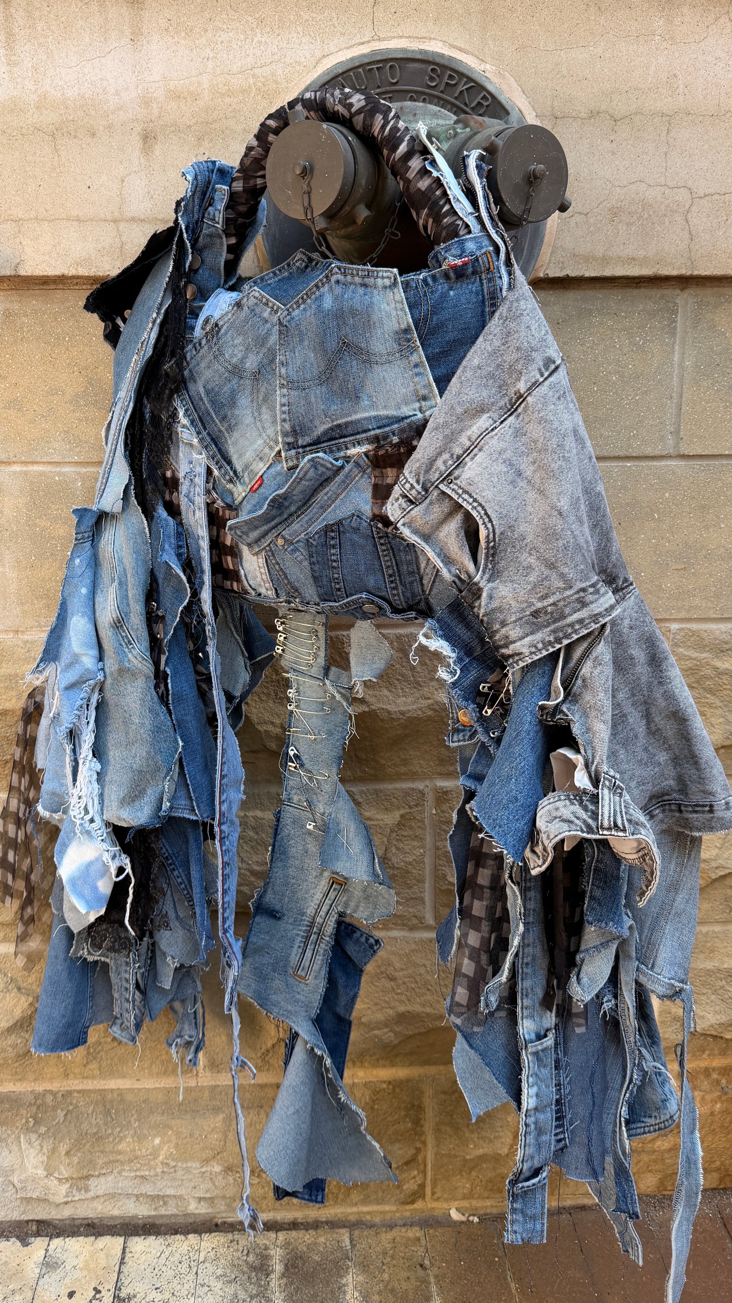 Close-up of upcycled ugly denim bag showing mixed denim patches, layered pocket design, lace detail, and distressed hanging strips.
