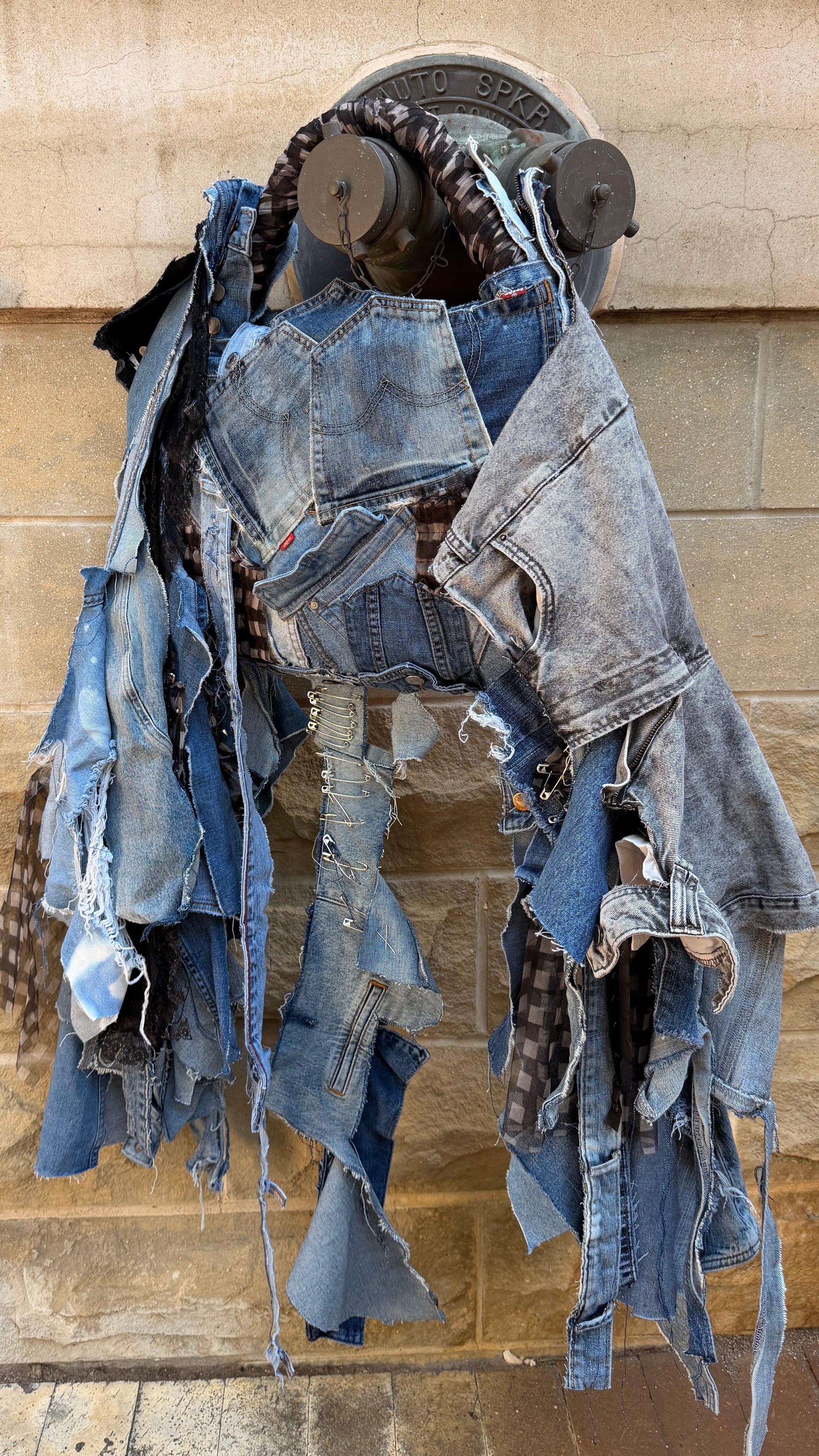 Close-up of upcycled ugly denim bag showing mixed denim patches, layered pocket design, lace detail, and distressed hanging strips.