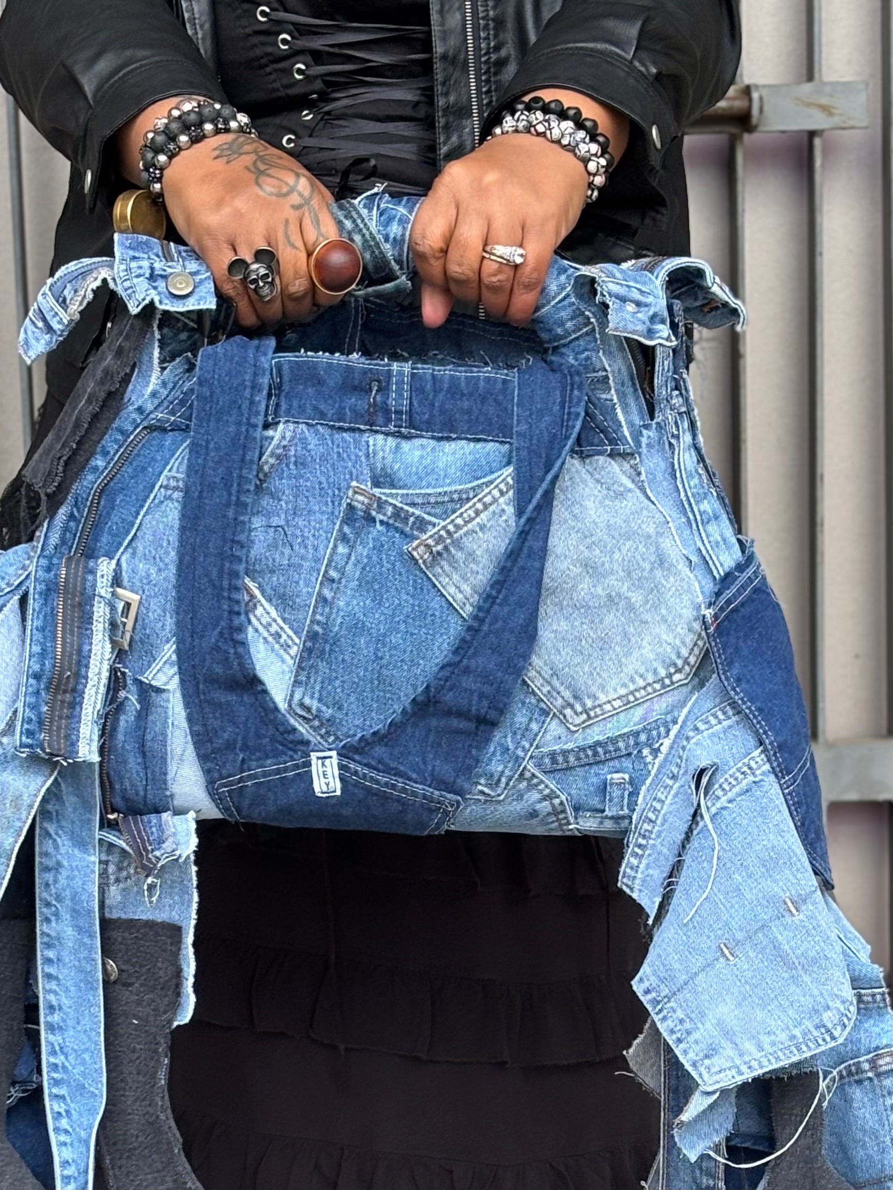 Person wearing a denim jacket with a focus on the jacket's design and details.