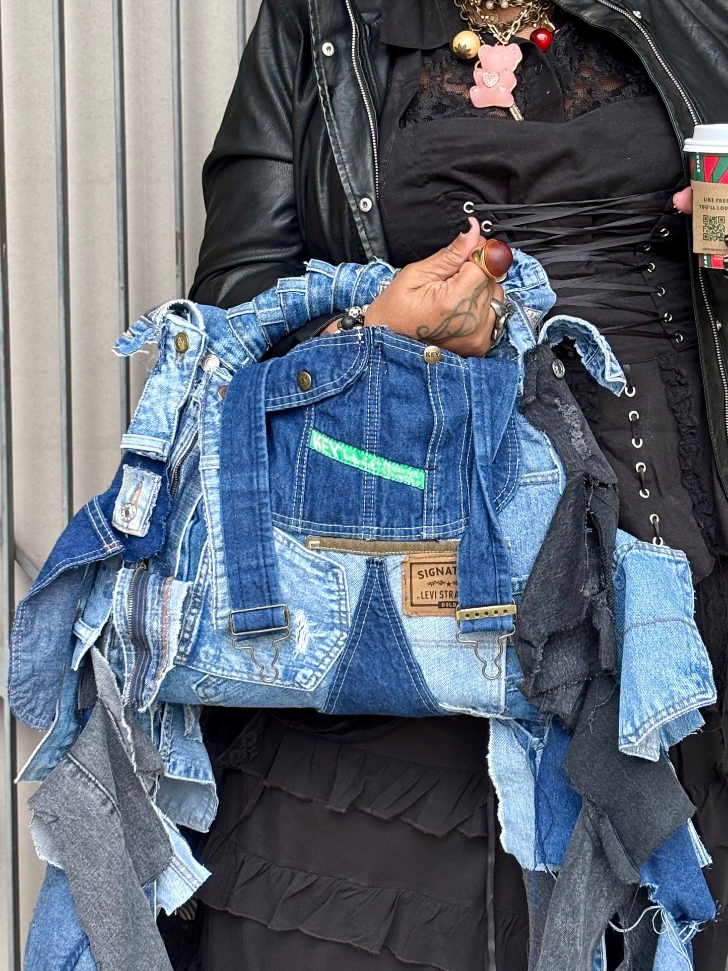 Person holding a denim jacket made from recycled jeans with a blurred background