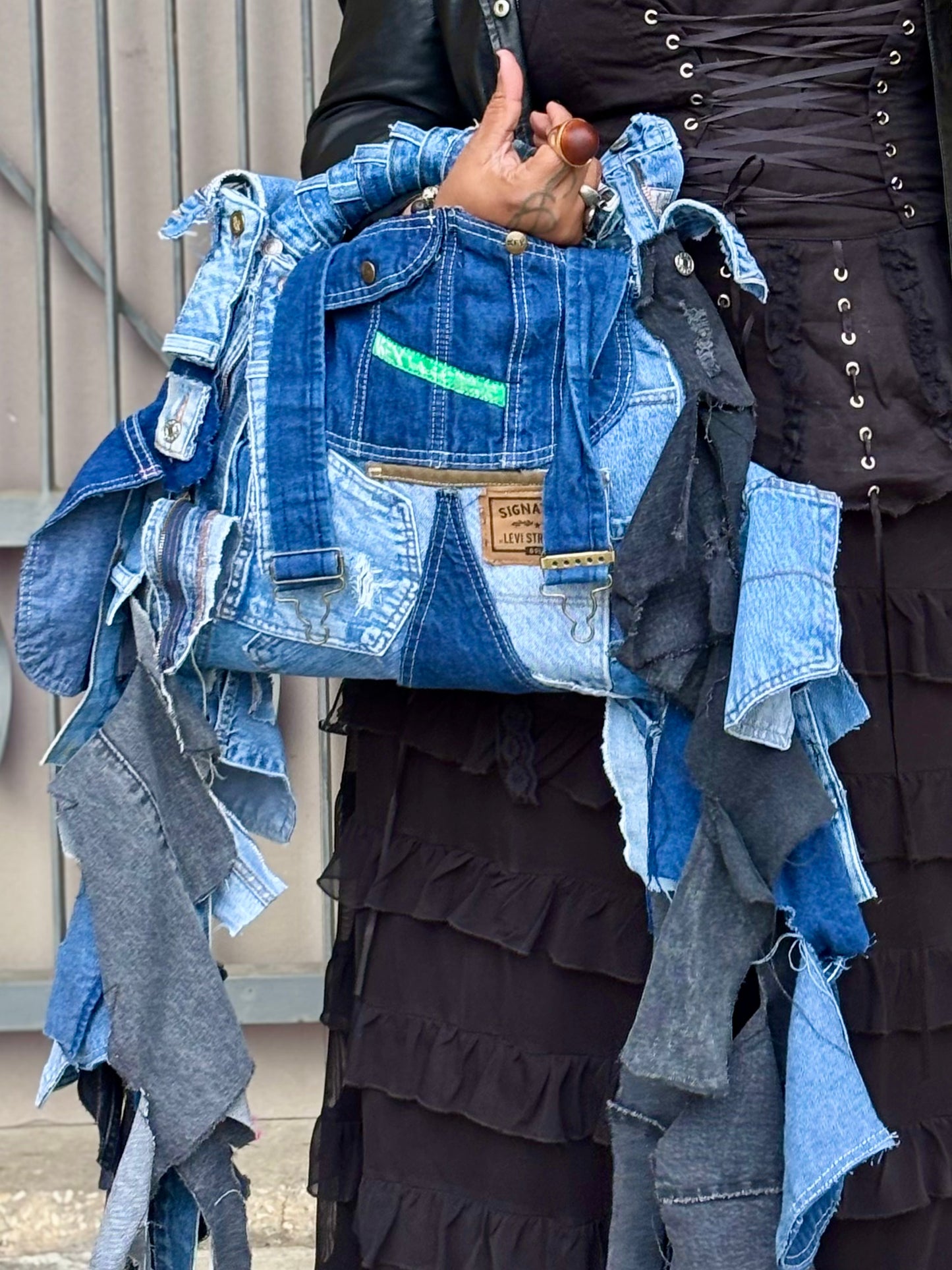 Woman holding a denim jacket made from recycled jeans with a visible brand label.