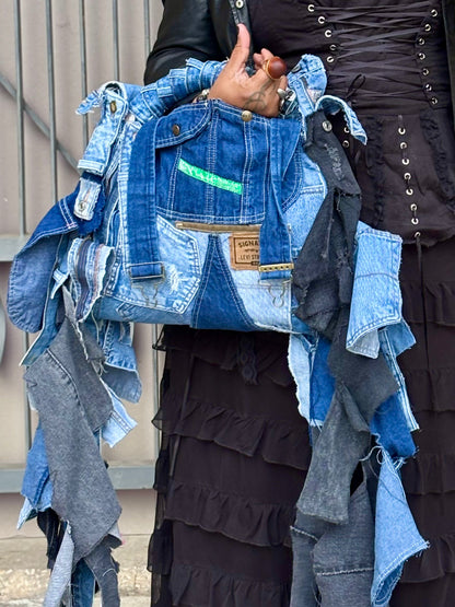 Woman holding a denim jacket made from recycled jeans with a visible brand label.