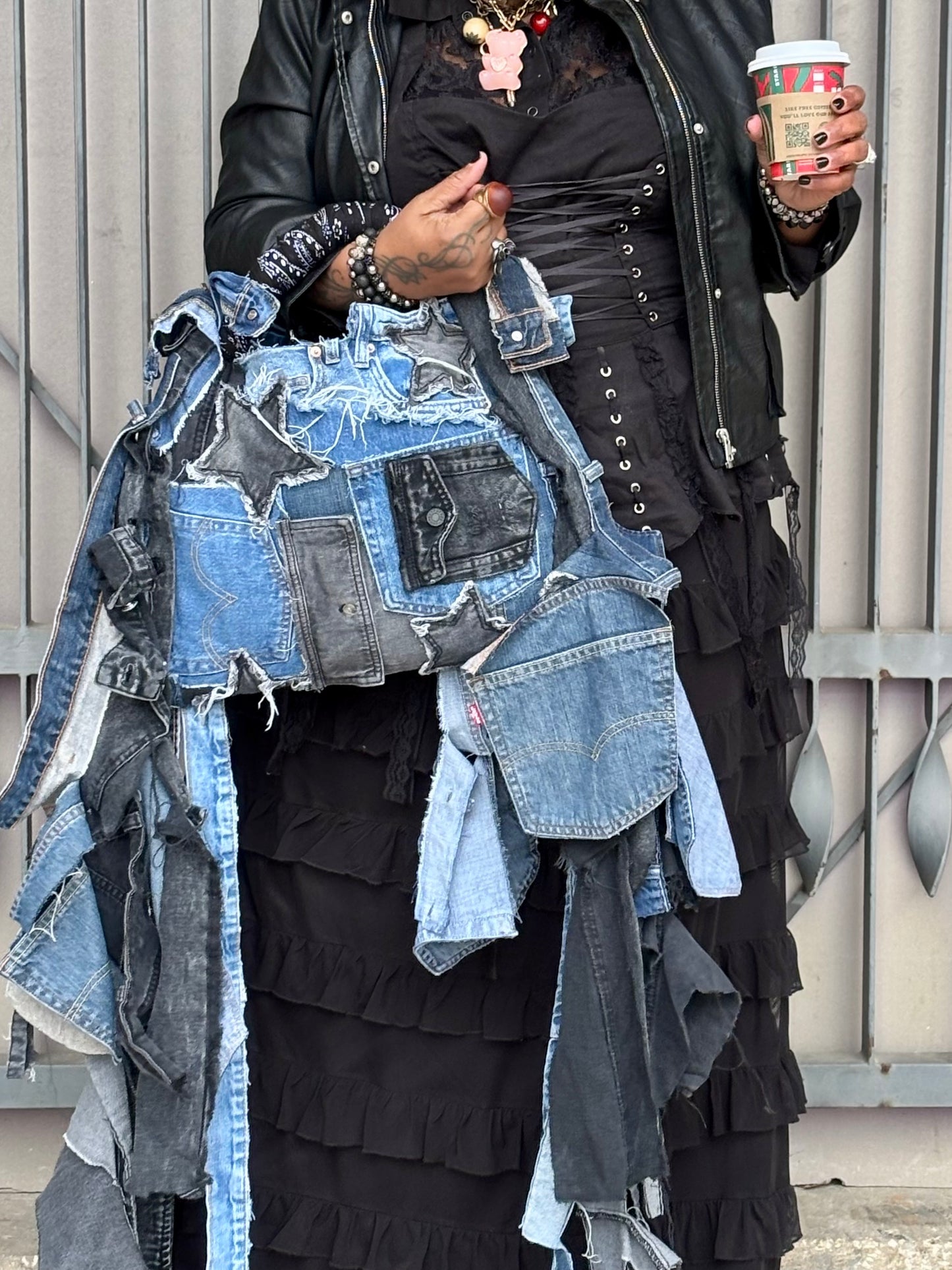 Woman holding denim bag with stars and patches , bandanna handle
