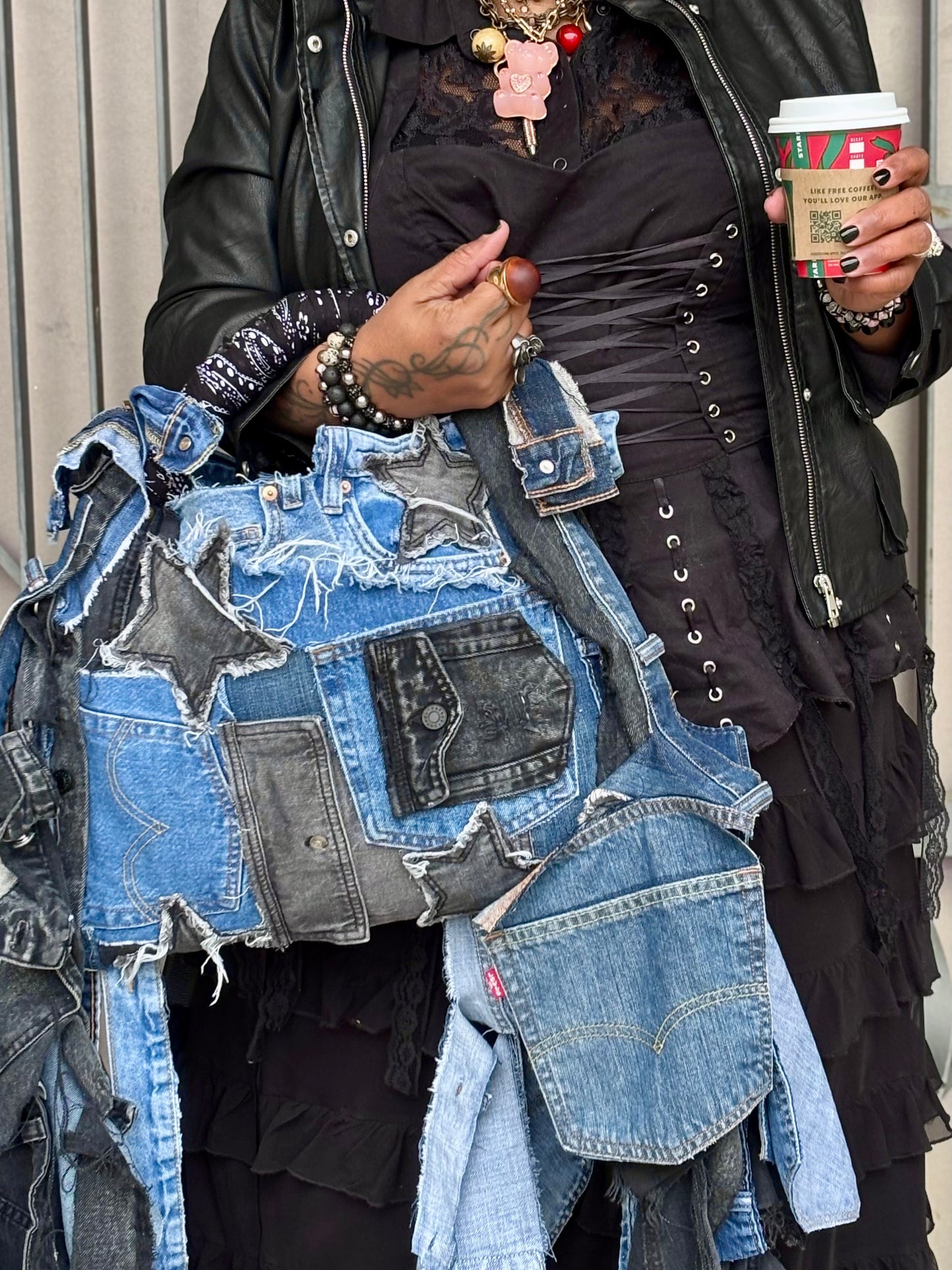 Woman holding denim bag with stars and patches , bandanna handle
