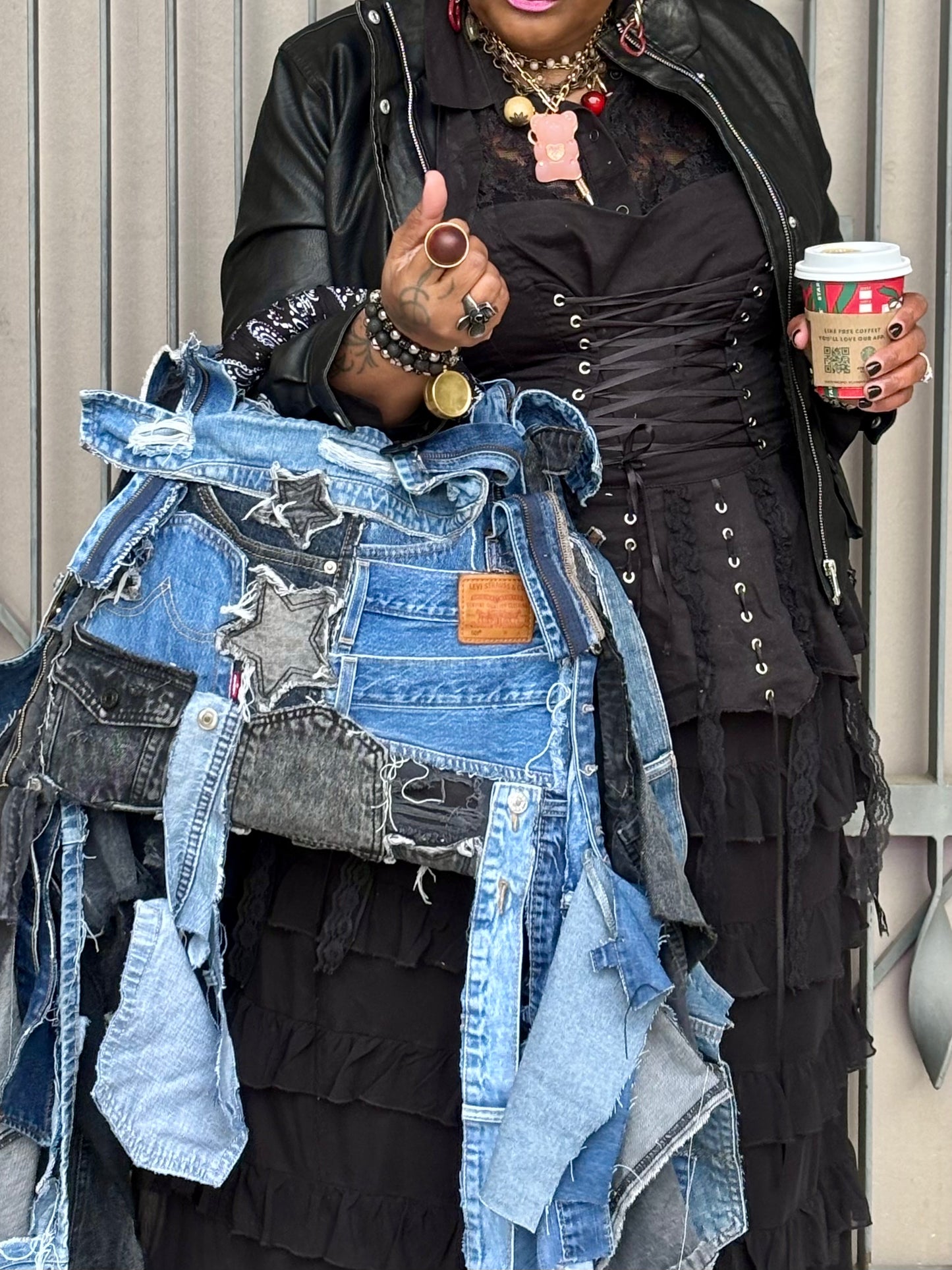 Woman holding denim bag with stars and patches , bandanna handle

