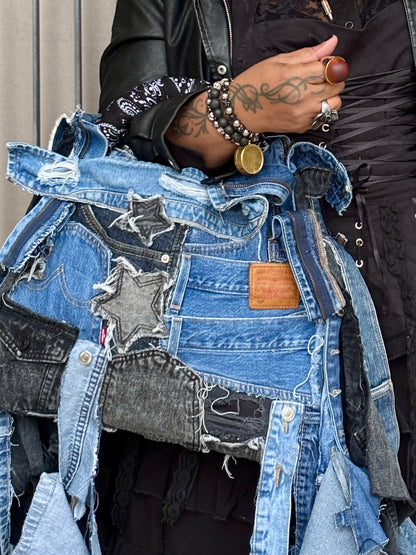 Woman holding denim bag with stars and patches , bandanna handle
