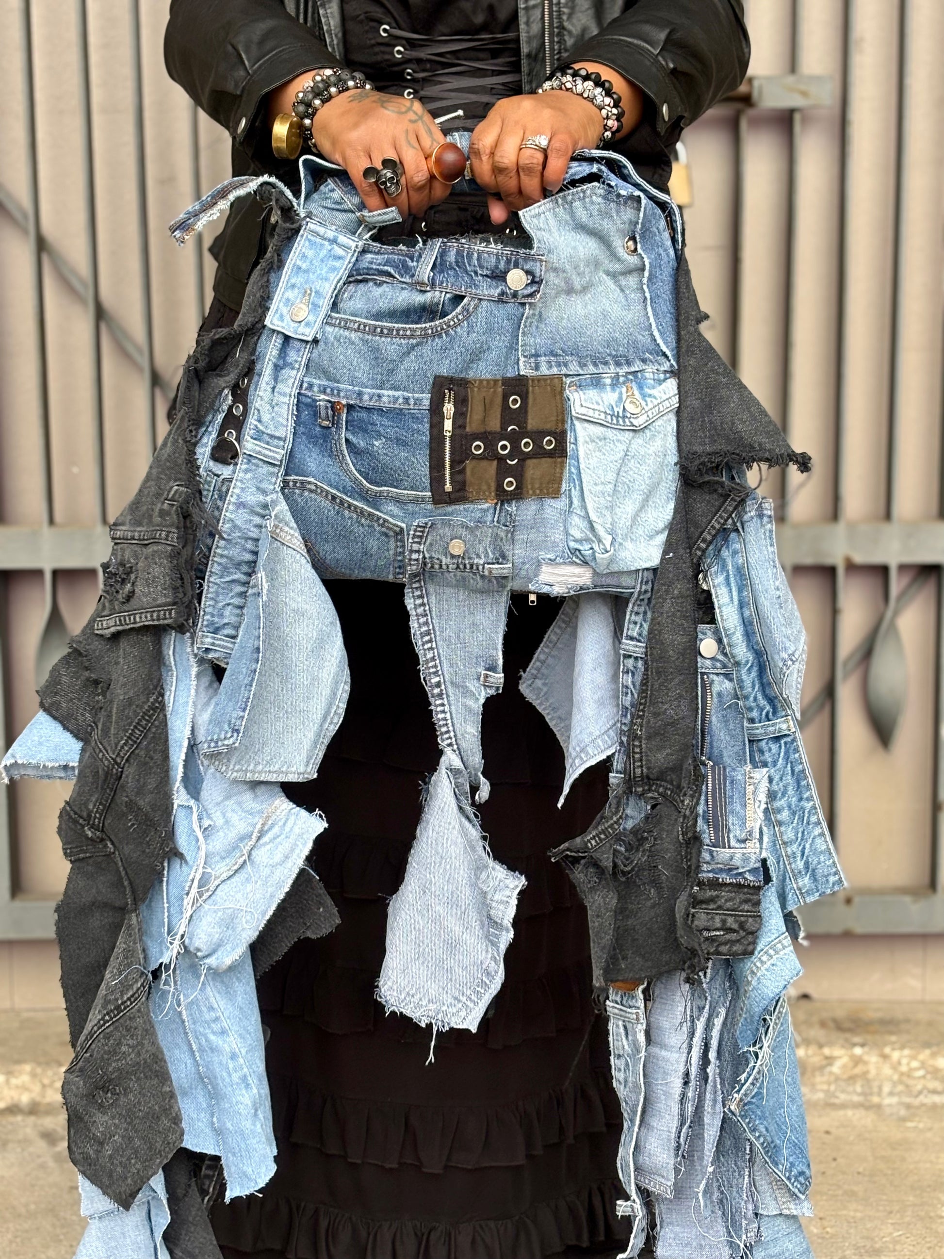 Person wearing a unique outfit made from repurposed denim and leather pieces.