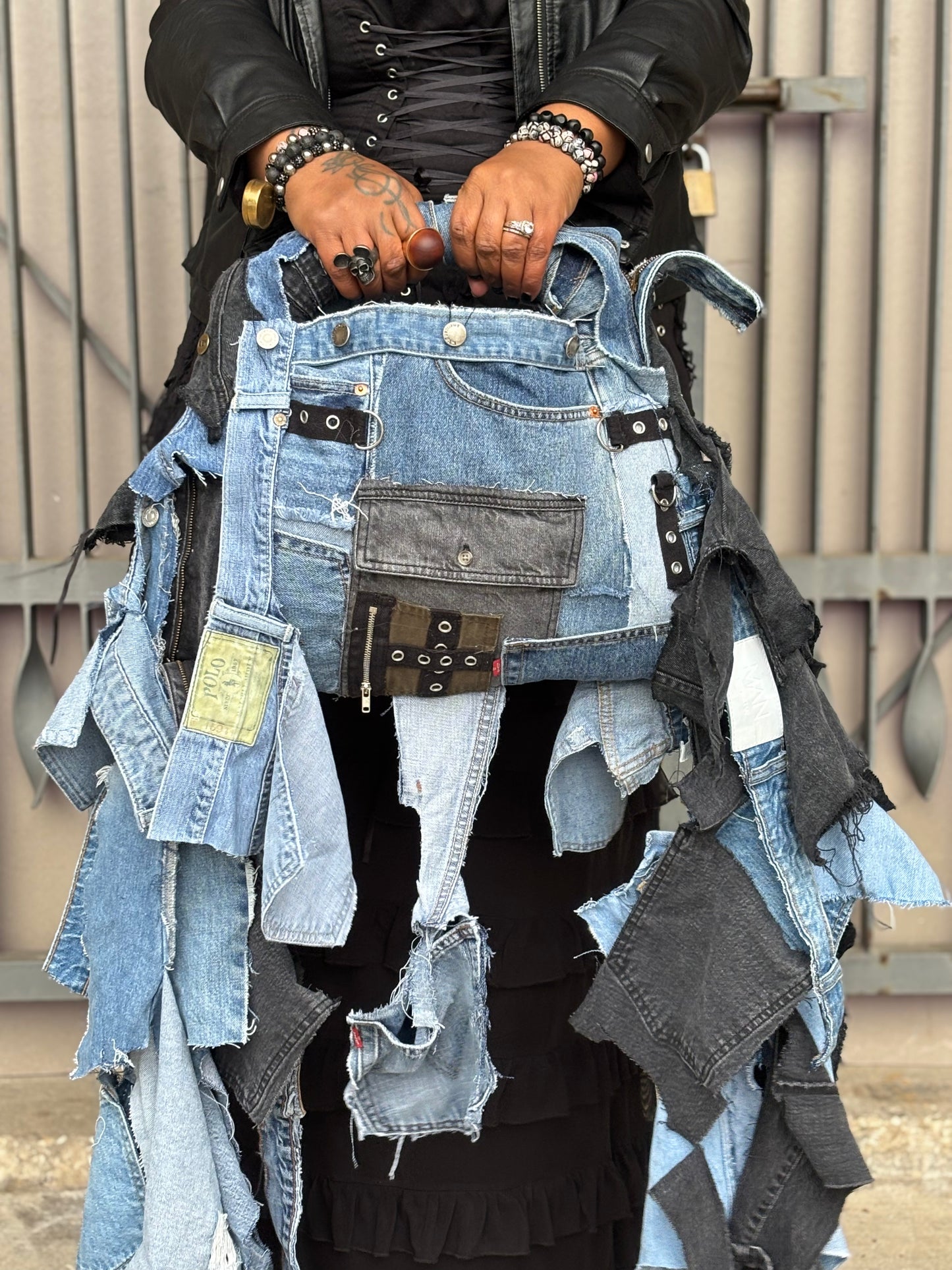 Person holding a collection of denim pieces against a neutral background