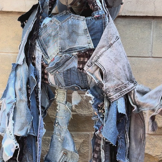 Woman showing off details of an ugly denim bag with lots of fray, denim and patches