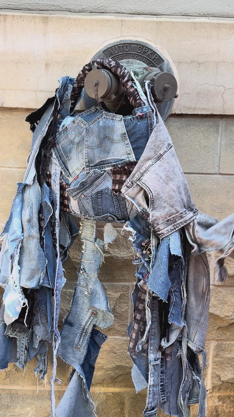 Woman showing off details of an ugly denim bag with lots of fray, denim and patches