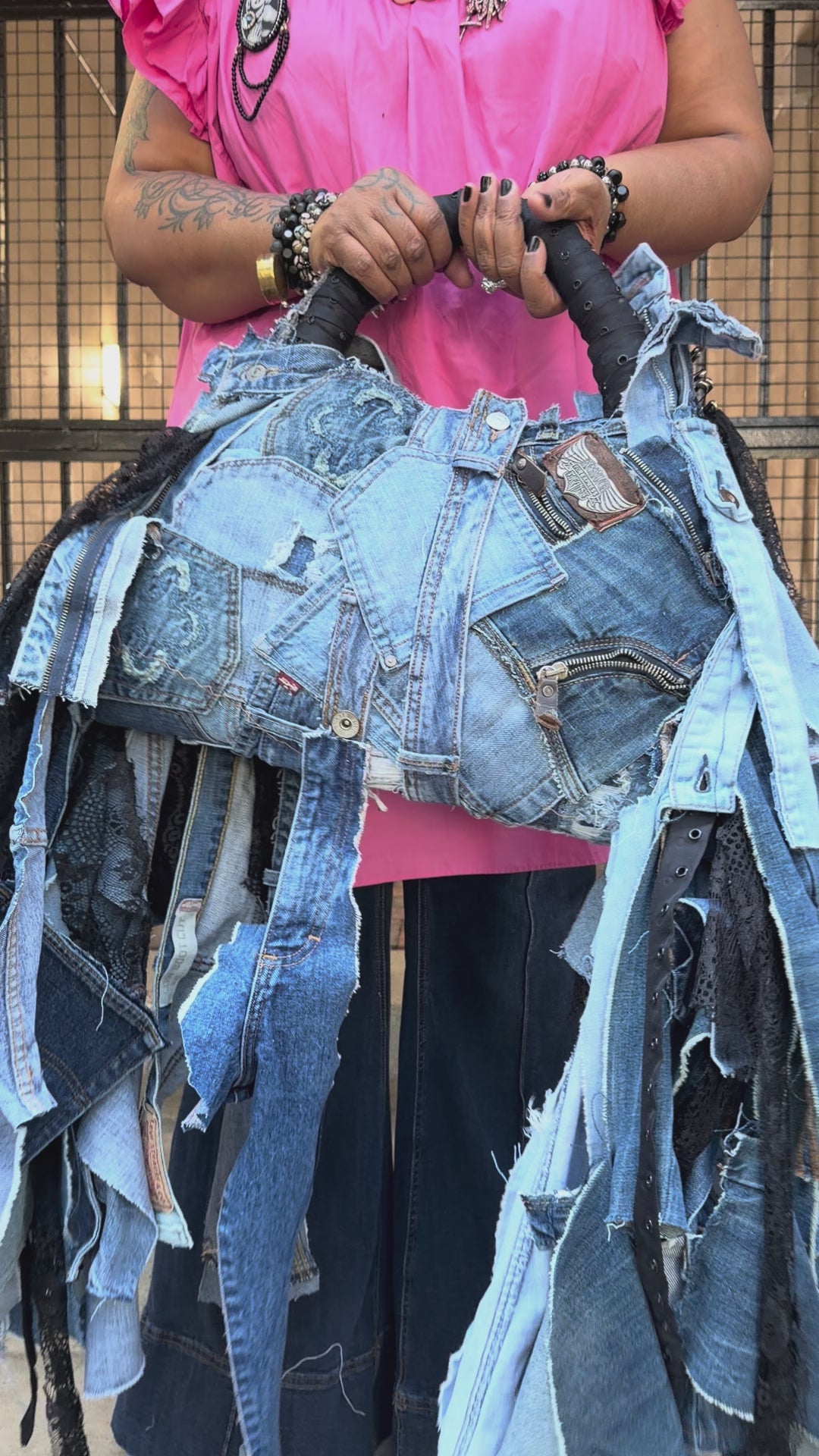 Person weaing pink to showing how to use denim bag